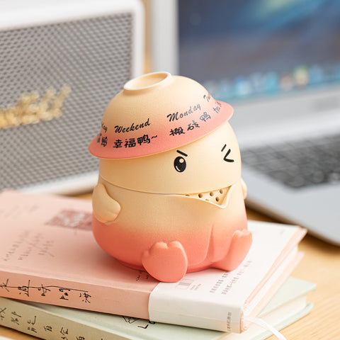 Weekday-themed rotating duck design on teapot lid for daily positivity.